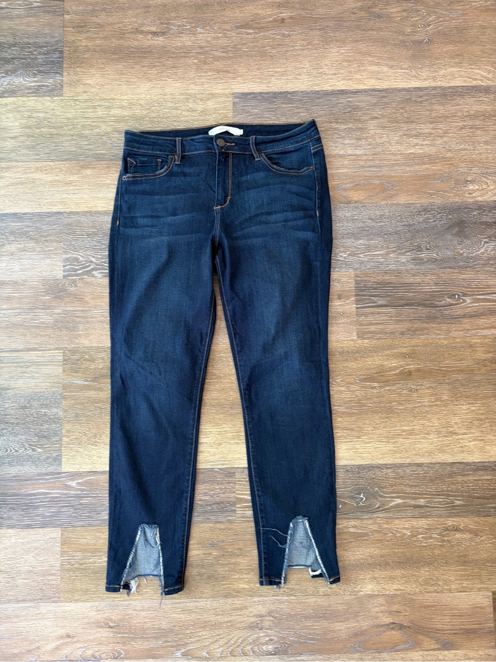Hidden dark wash jeans with distinct raw, v-cut split hem at the ankle size 31